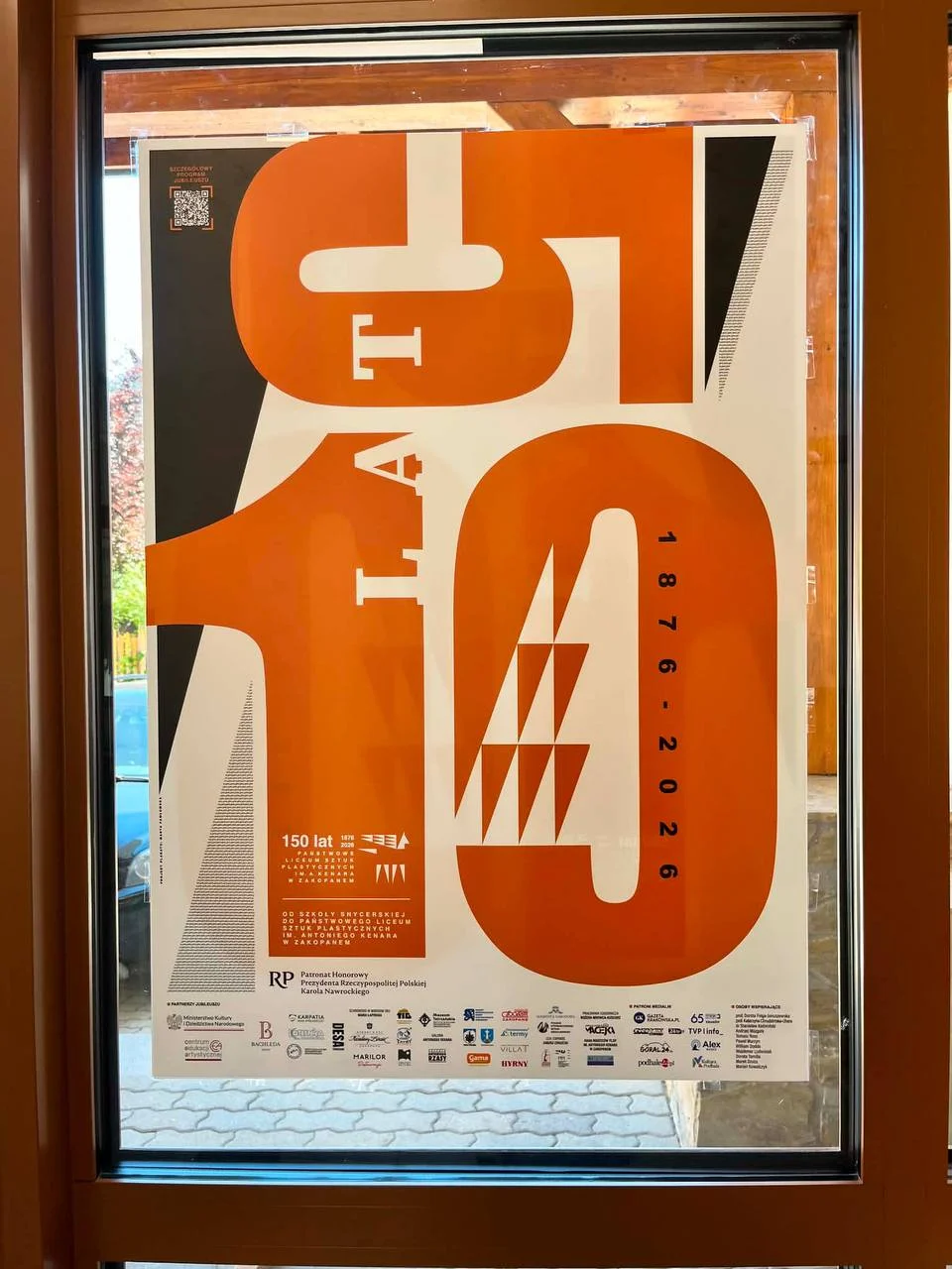 Plakat jubileuszowy 150-lecia w oknie Liceum Plastycznego im. Antoniego Kenara w Zakopanem
